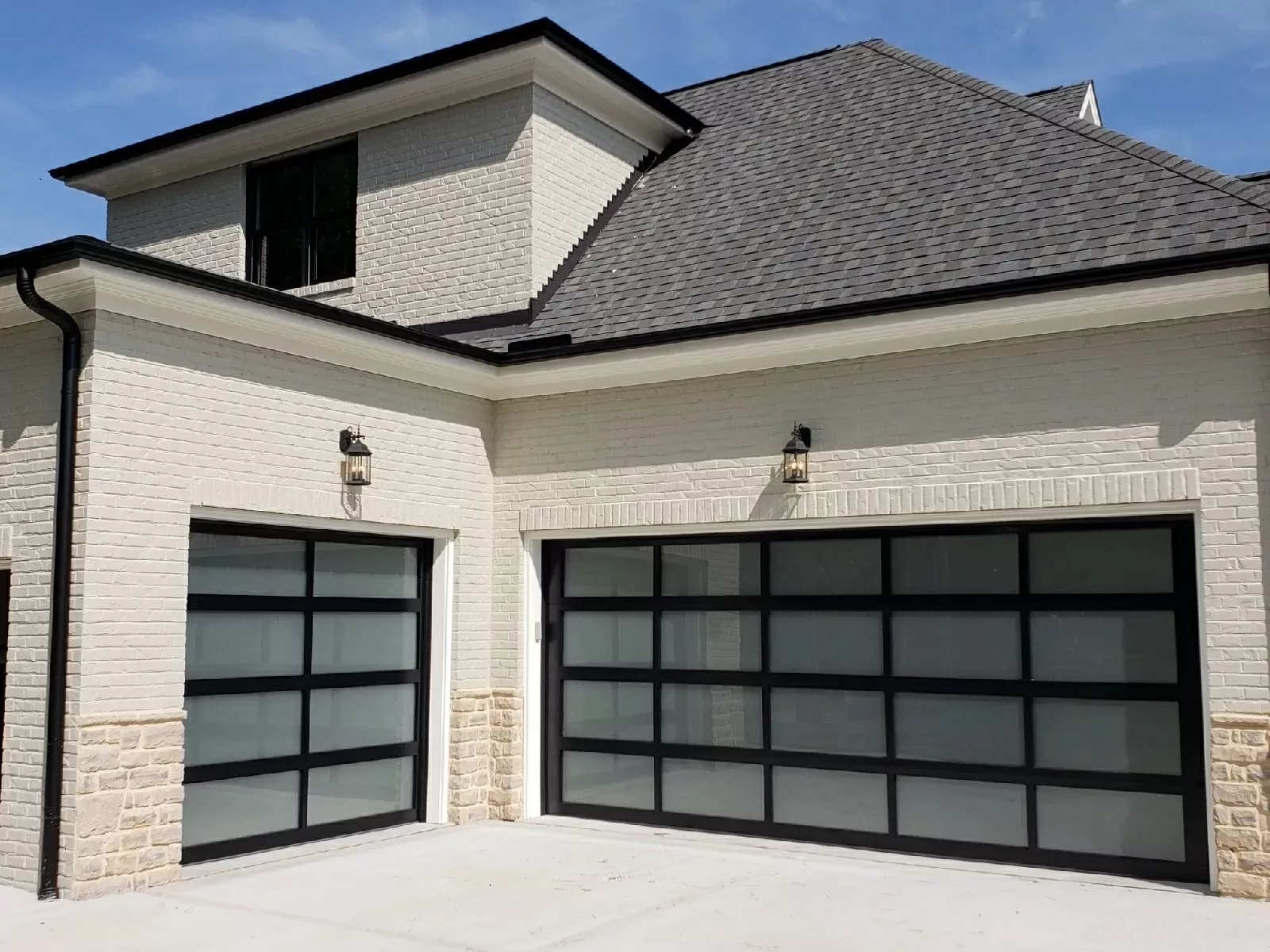 Modern black aluminum and glass garage doors installed at a Dallas–Fort Worth home