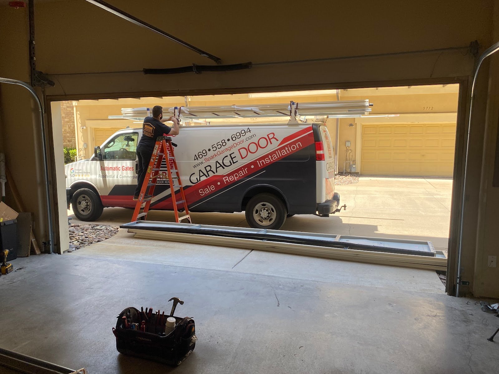 Garage door technician servicing residential door hardware